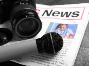 Newspaper,With,Microphone,And,Photo,Camera,On,Dark,Background,,Closeup
