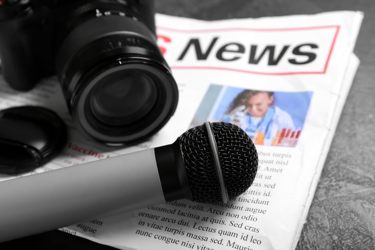 Newspaper,With,Microphone,And,Photo,Camera,On,Dark,Background,,Closeup